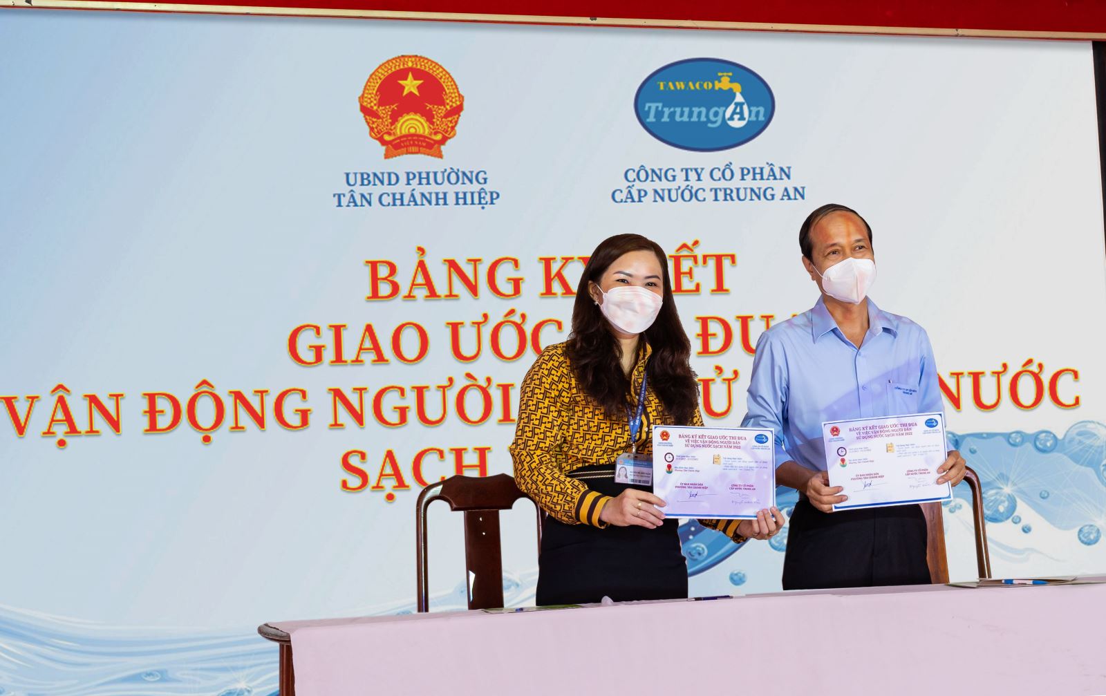 Bà Nguyễn Thị Thuỳ Ngân - Phó Chủ tịch phường Tân Chánh Hiệp và ông Nguyễn Minh Hải - Phó Giám Đốc Công ty Cổ phần Cấp nước Trung An cùng ký giao ước thi đua vận động sử dụng nước sạch.